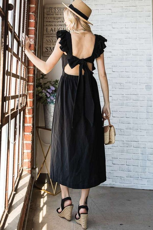 Black midi dress showing open back with bow tie and ruffled cap sleeves