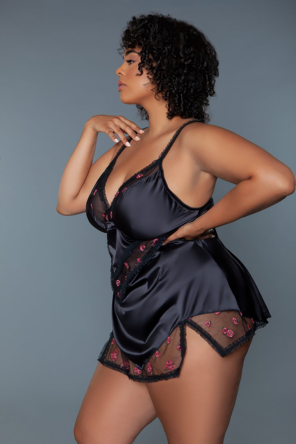 Black babydoll chemise in profile with pink rose embroidery, lace-trimmed hem and straps