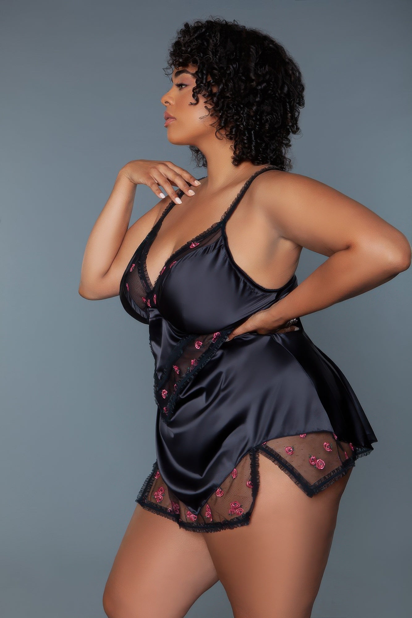 Black babydoll chemise in profile with pink rose embroidery, lace-trimmed hem and straps