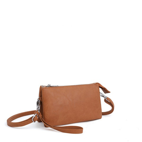 Cognac compact crossbody purse from side view with short wrist strap and zipper