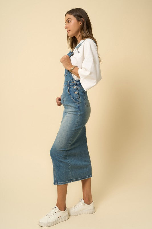Denim blue long skirt overalls, side view, with tapered leg opening and bib front