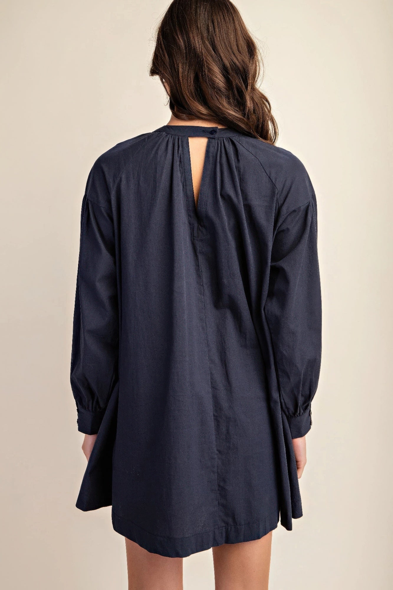 Back view of navy long-sleeve mini dress with keyhole neckline and button