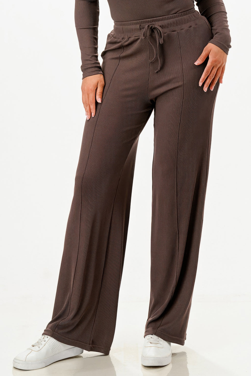 Leg close-up: dark brown wide-leg pants with drawstring waist and smooth ribbed texture
