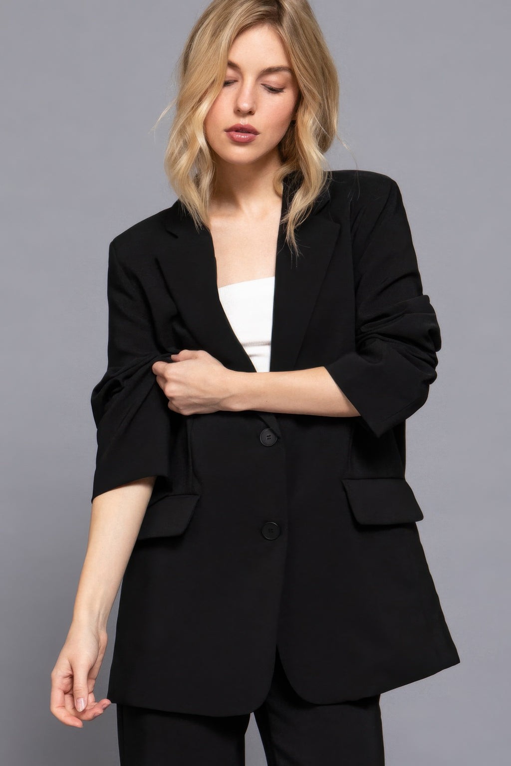 Black blazer front button closure, patch pockets and three-quarter sleeves.
