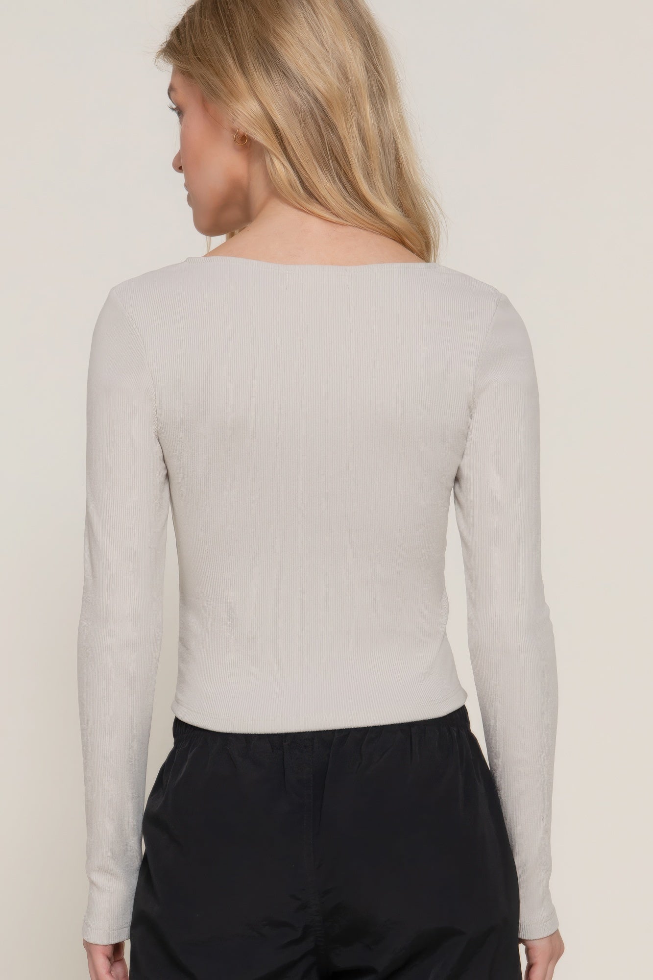 Long-sleeve knit top back view, ribbed texture, light color