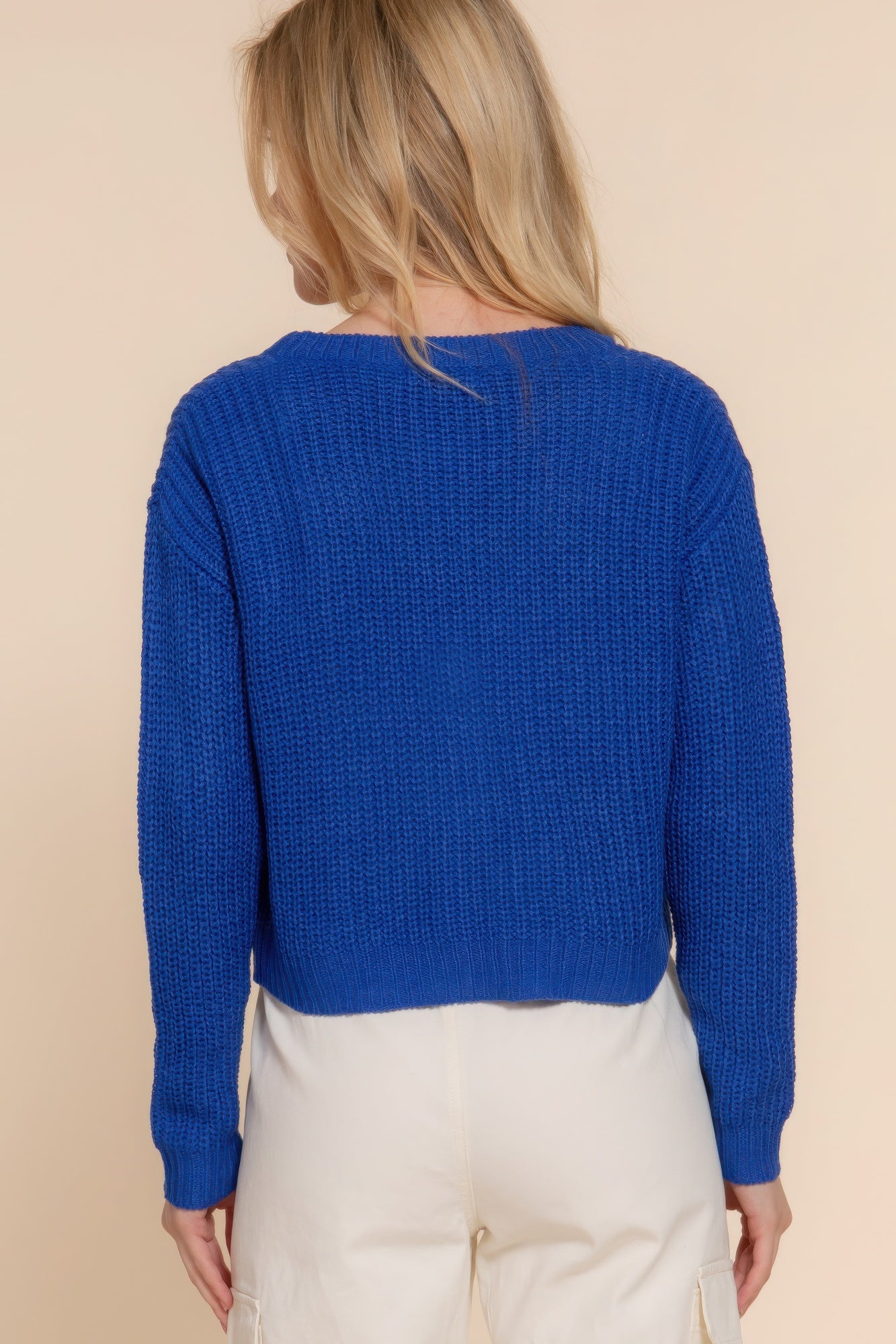 Blue knit cardigan back view with long sleeves and cropped hem
