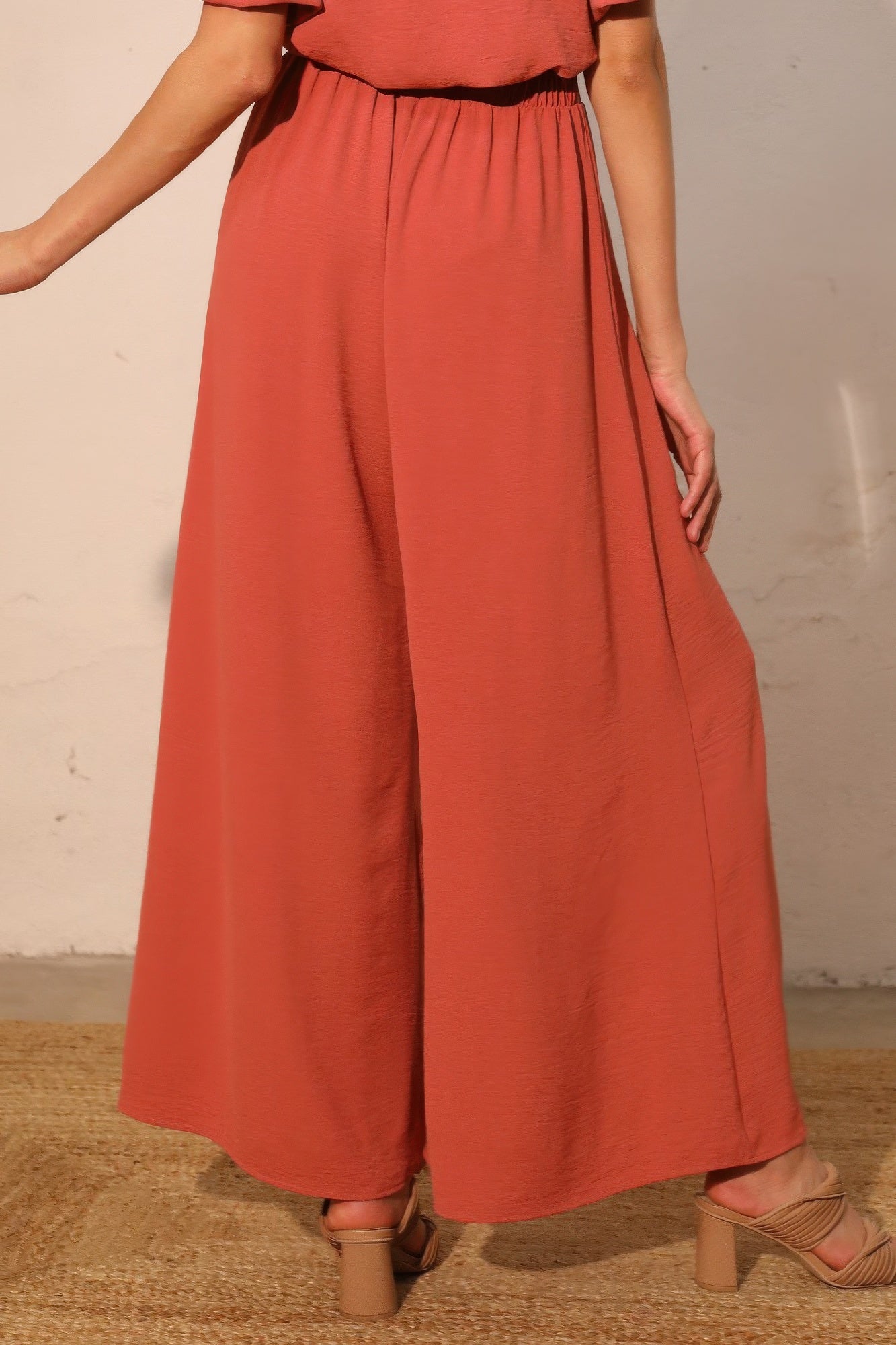Rust wide-leg swing pants with elastic waist, matte crepe drape, wide hem
