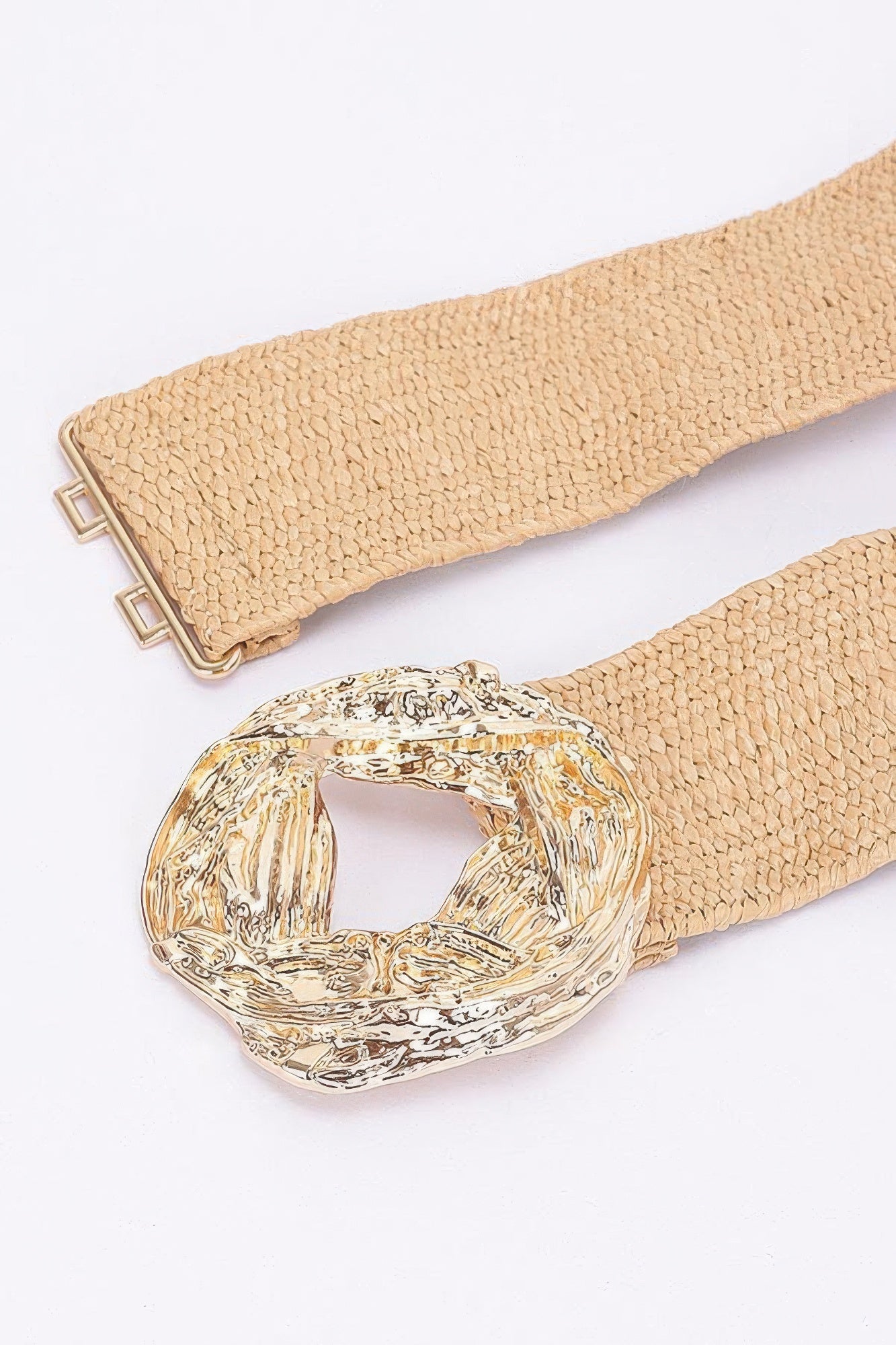 Beige belt close-up: textured strap with double-prong metal buckle