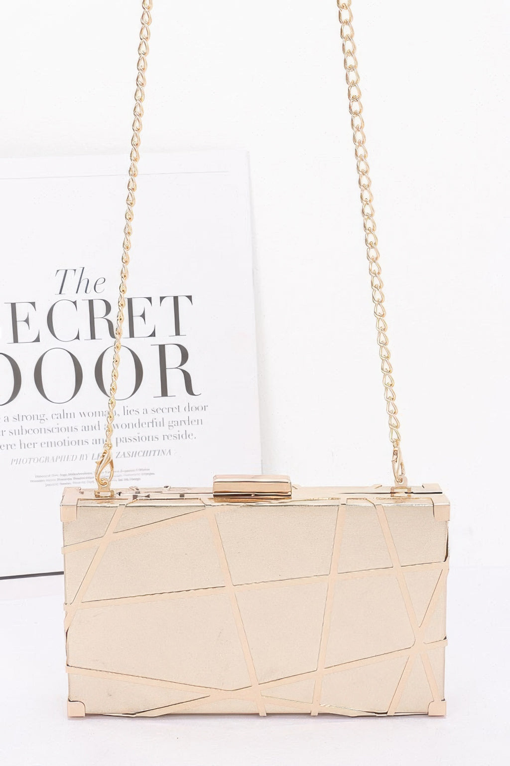 Gold metallic case clutch with chain shoulder strap and hinged top frame