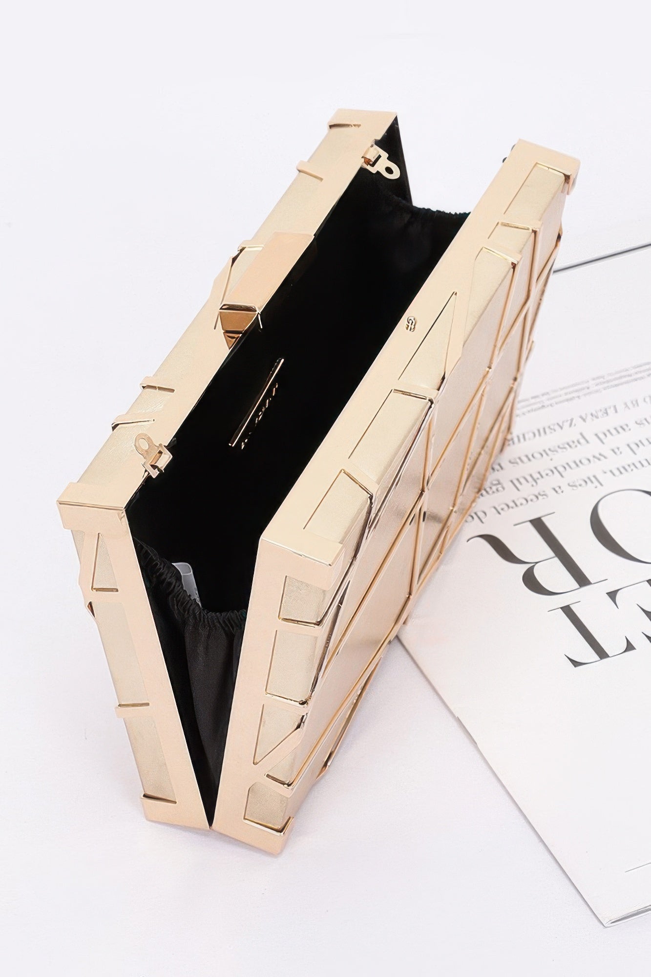 Gold metallic case clutch with black-lined interior and hinged top clasp