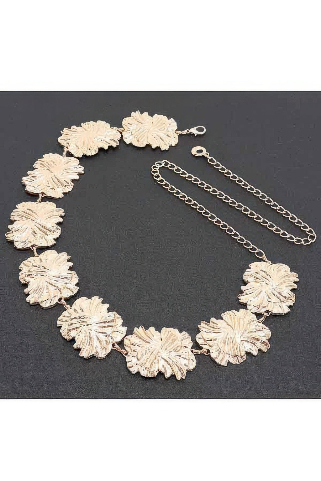 Gold metal chain belt laid flat, textured flower links with clasp and extender
