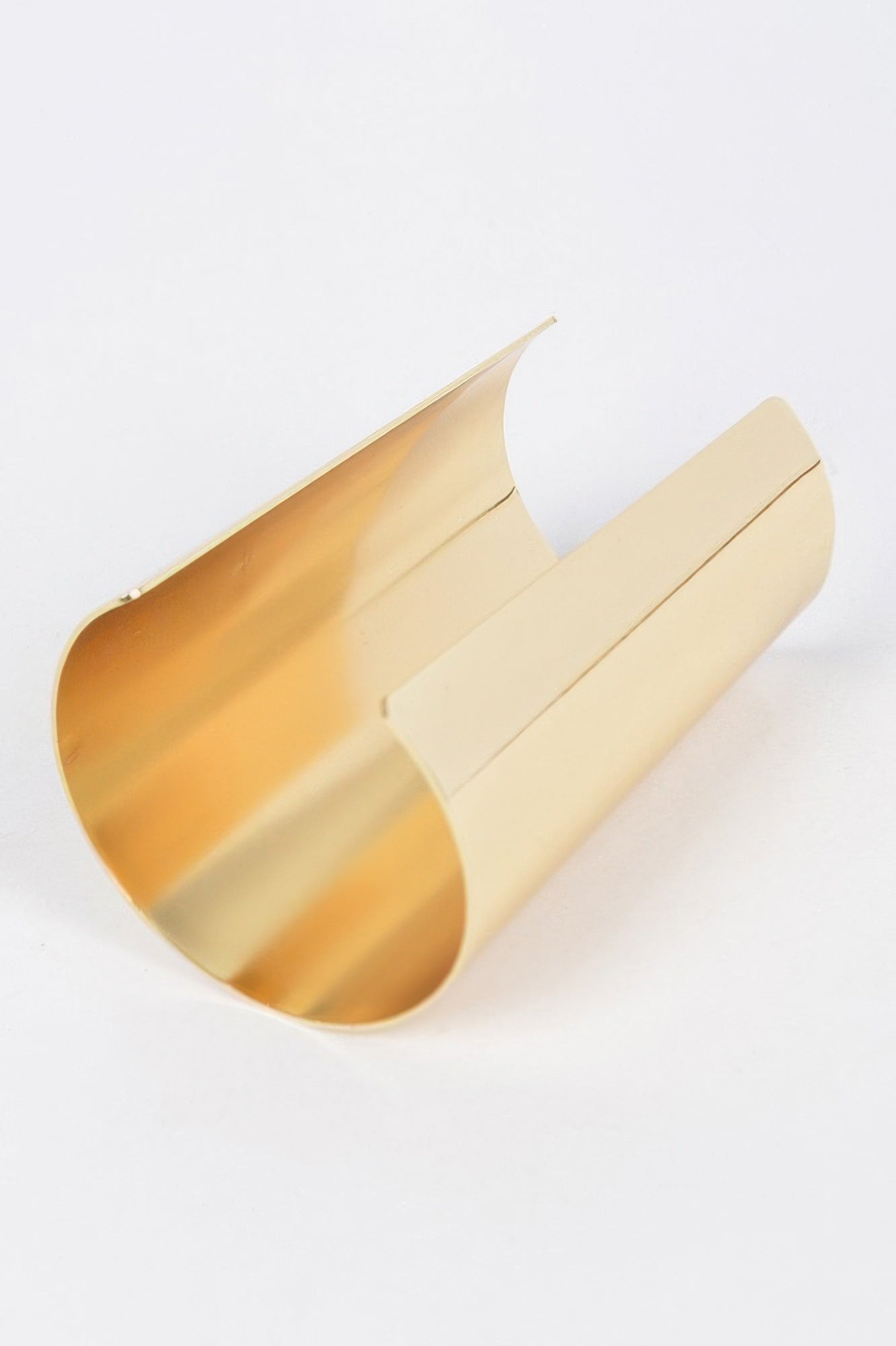 Polished gold metal cuff with wide arc opening and clean seam detail