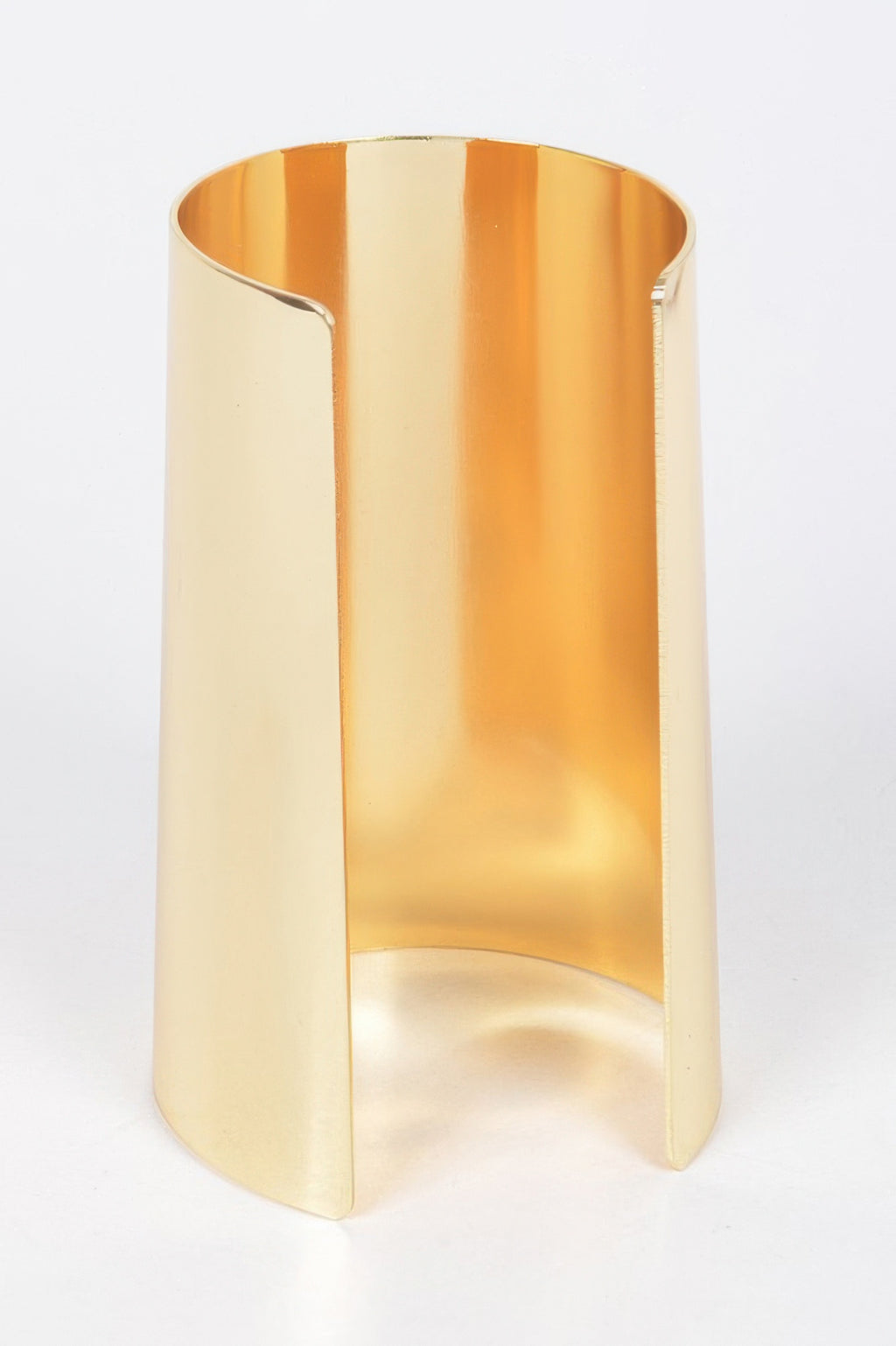 Gold metal cuff with angular cutout and glossy polished surface