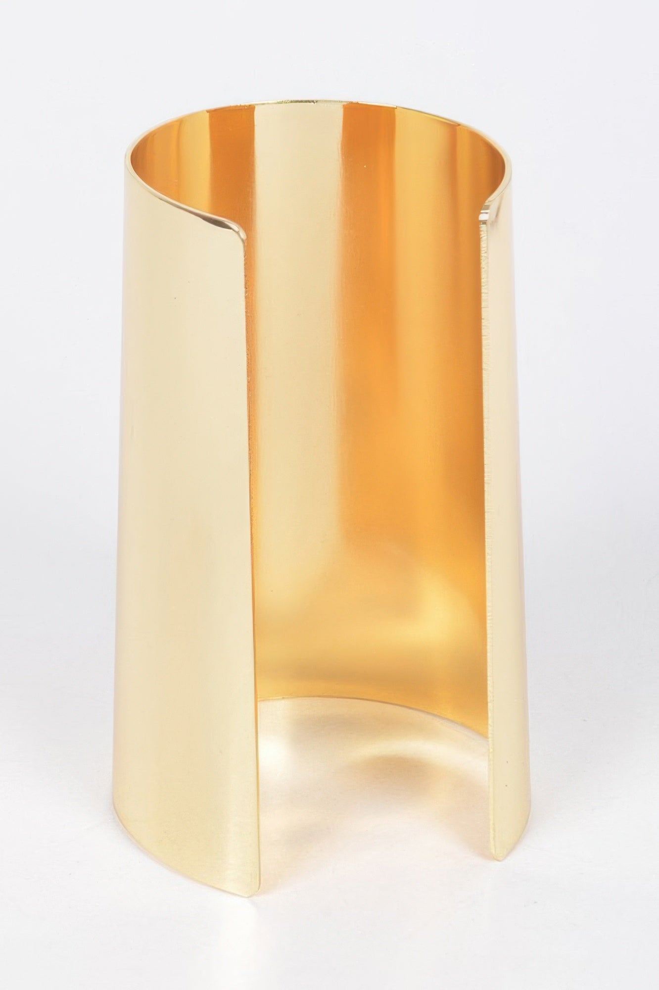Gold metal cuff with angular cutout and glossy polished surface