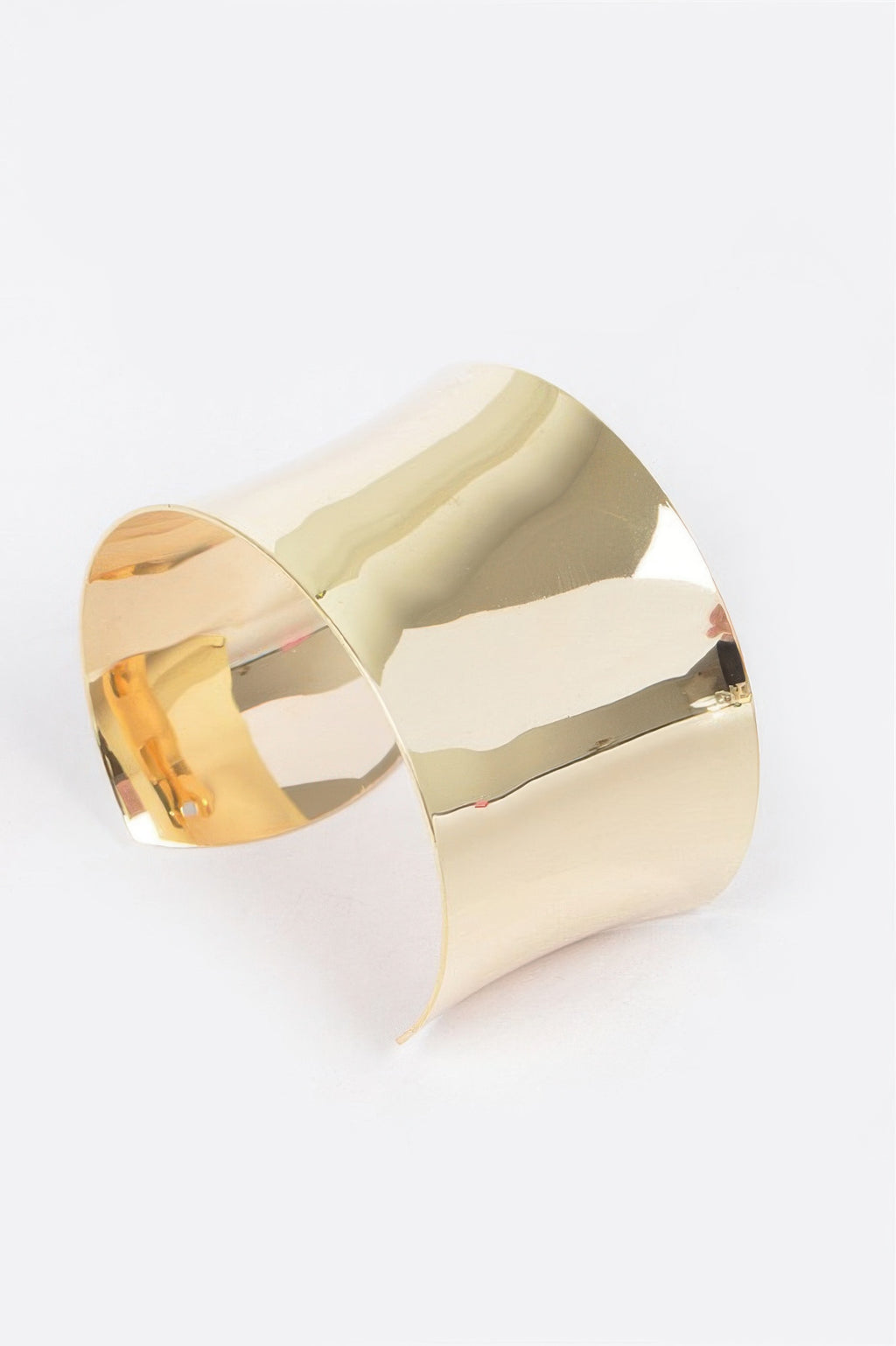 Gold cuff bracelet, angled view with smooth reflective finish