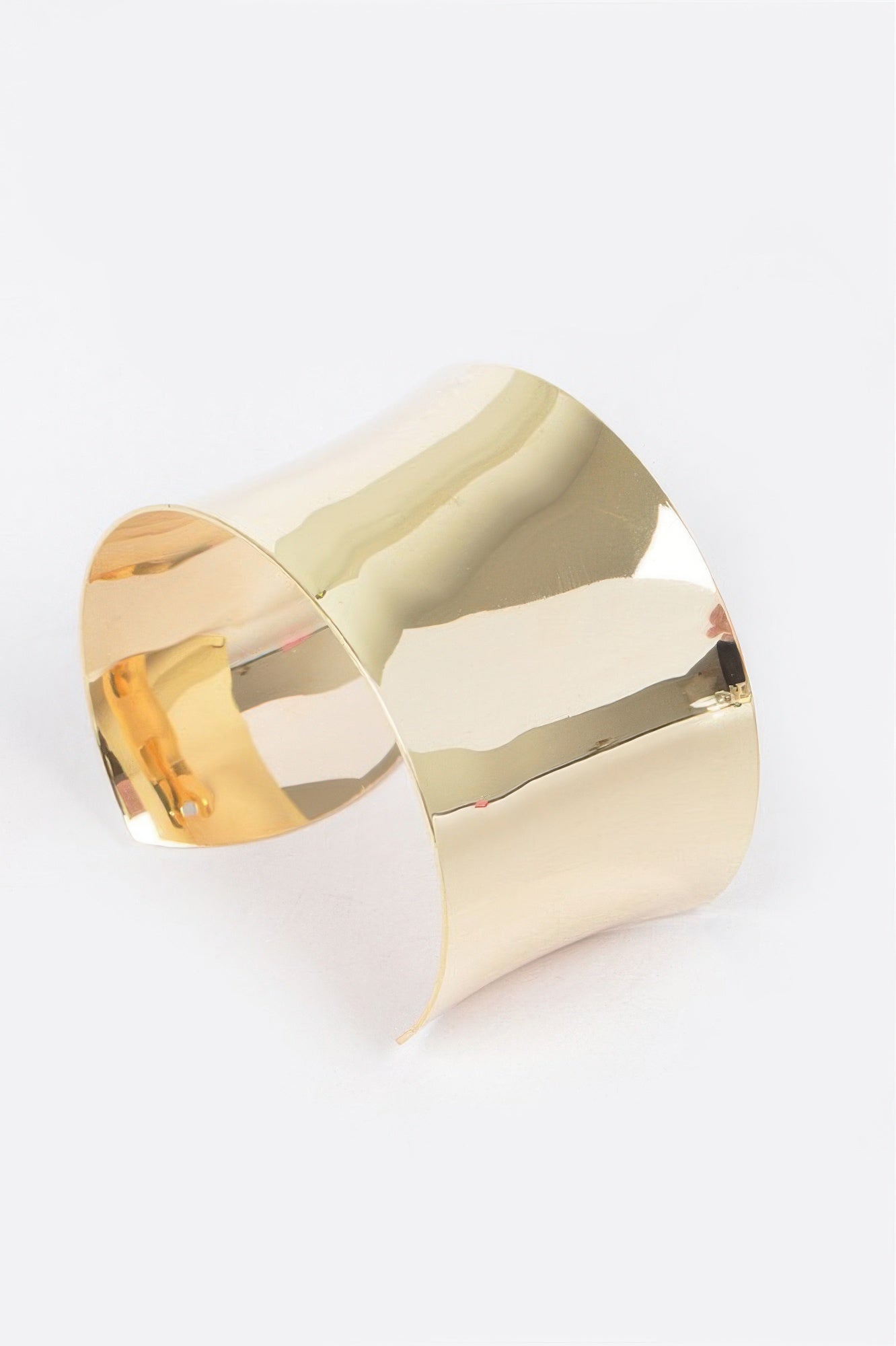 Gold cuff bracelet, angled view with smooth reflective finish