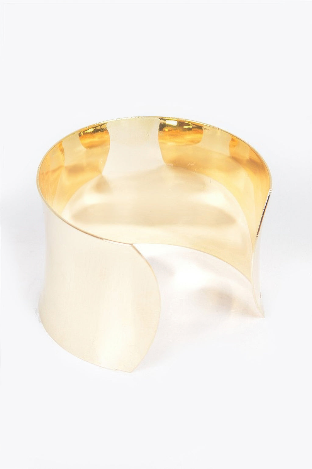 Gold metal cuff bracelet inside view, curved smooth surface