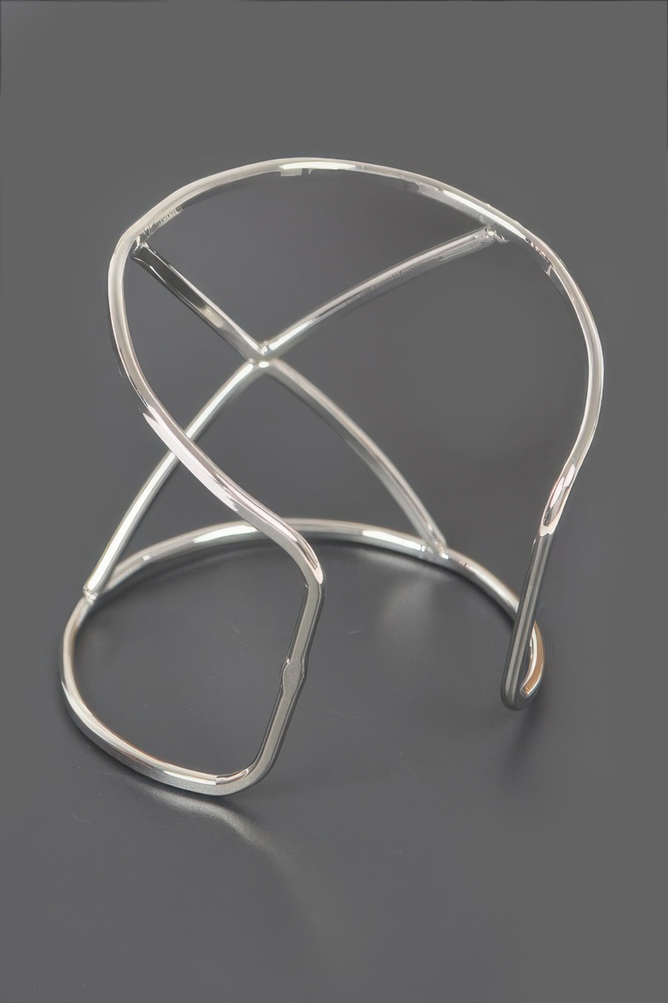 Silver metal cuff bracelet with open geometric bars and curved spring-like ends
