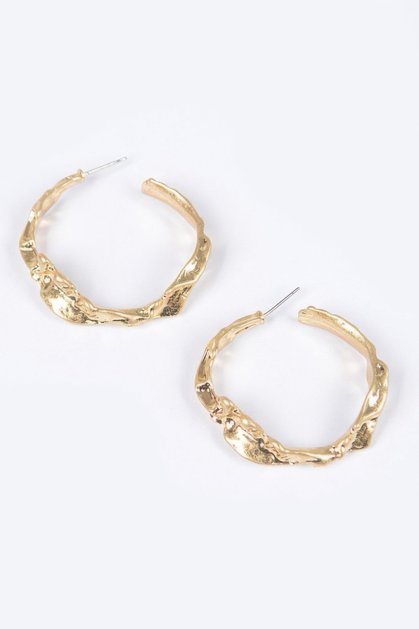 Pair of gold textured metal hoop earrings, side view showing clasp studs