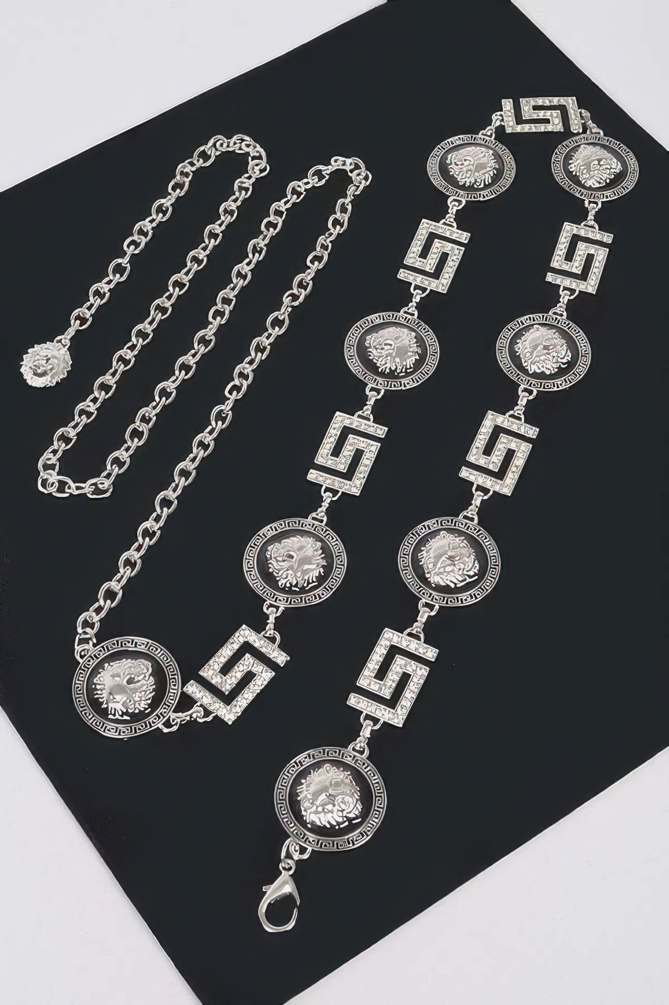 Ketten-Gürtel-Set: mehrere silberne Anhänger mit Strass, Medaillons und geometrischen Gliedern