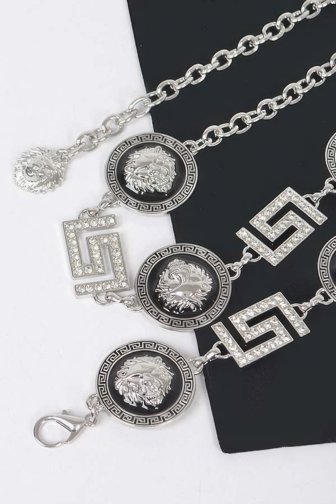 Nahaufnahme Silber-Ketten-Gürtel: Medaillons, große Strass-Buchstaben und Karabiner