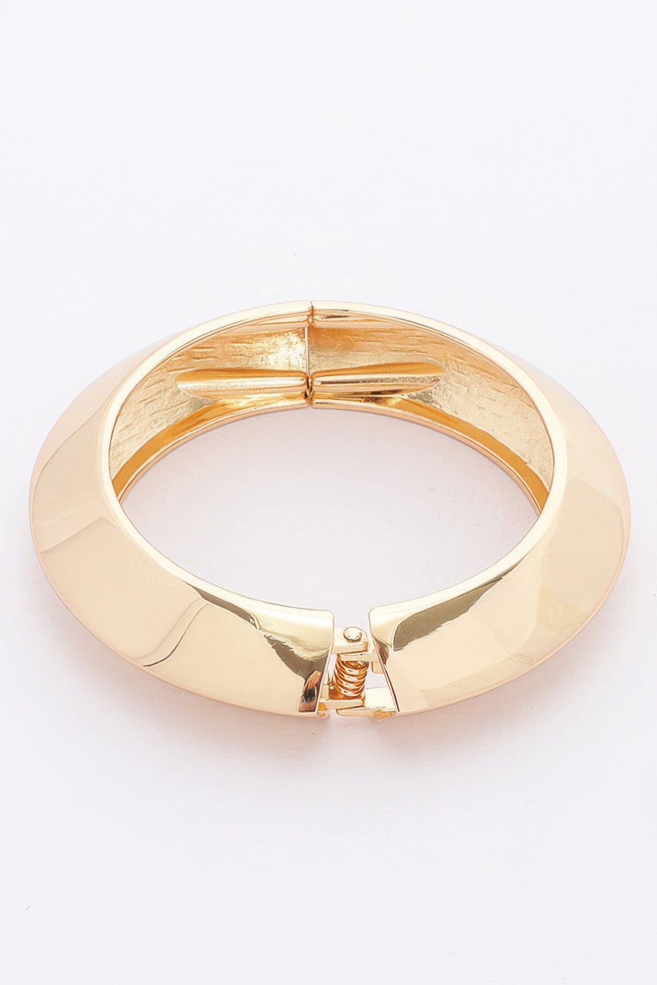 Gold metal spring hinge bracelet with central hinge and spiral spring detail.