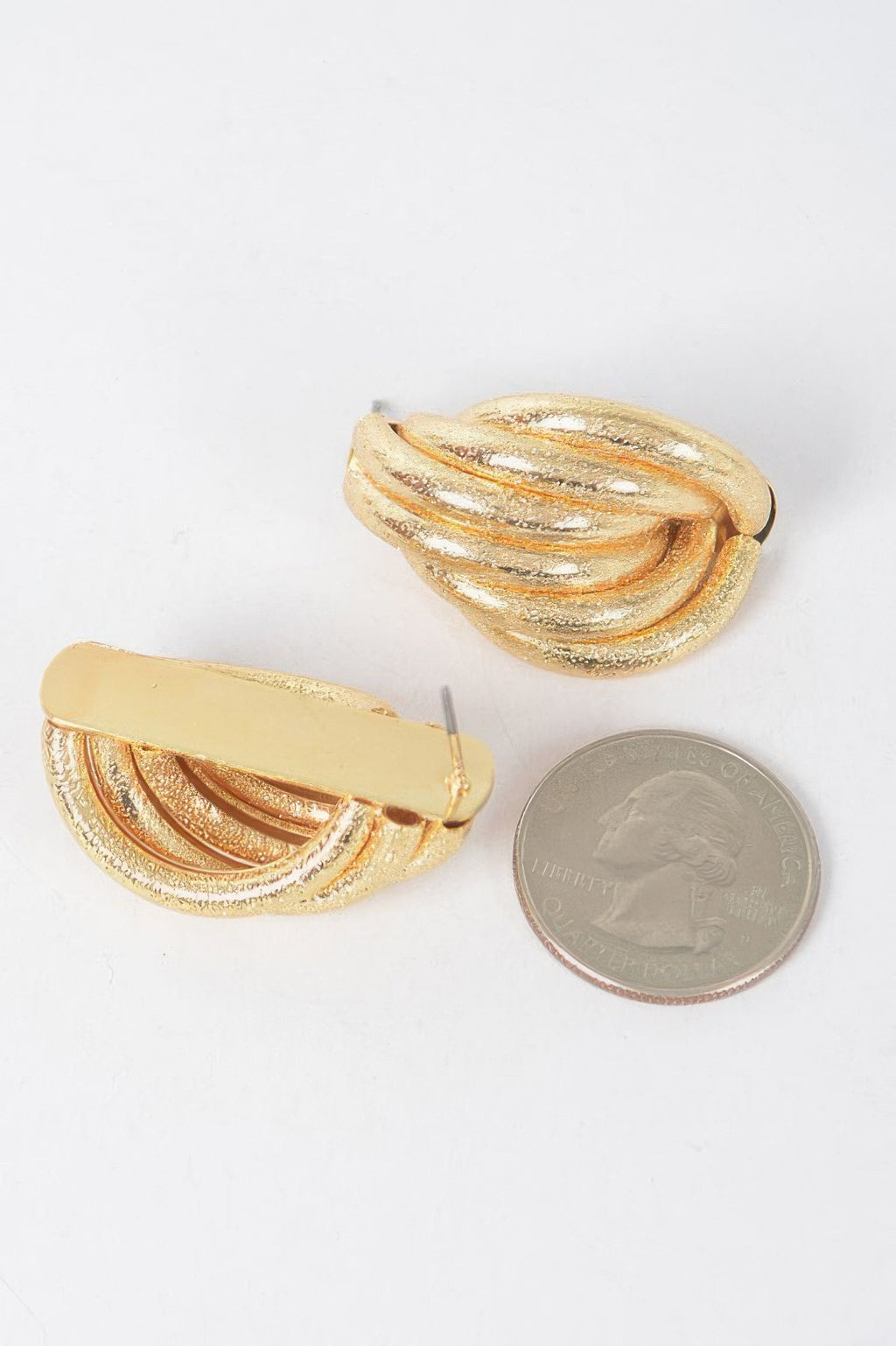 Gold teardrop metal stud earrings with flat back post; textured ridges