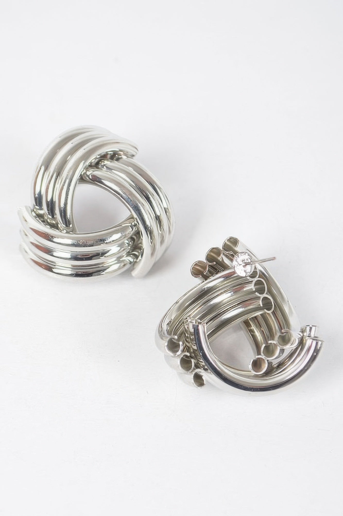 Silver metal stud hoop earrings with layered rings and small button-like studs