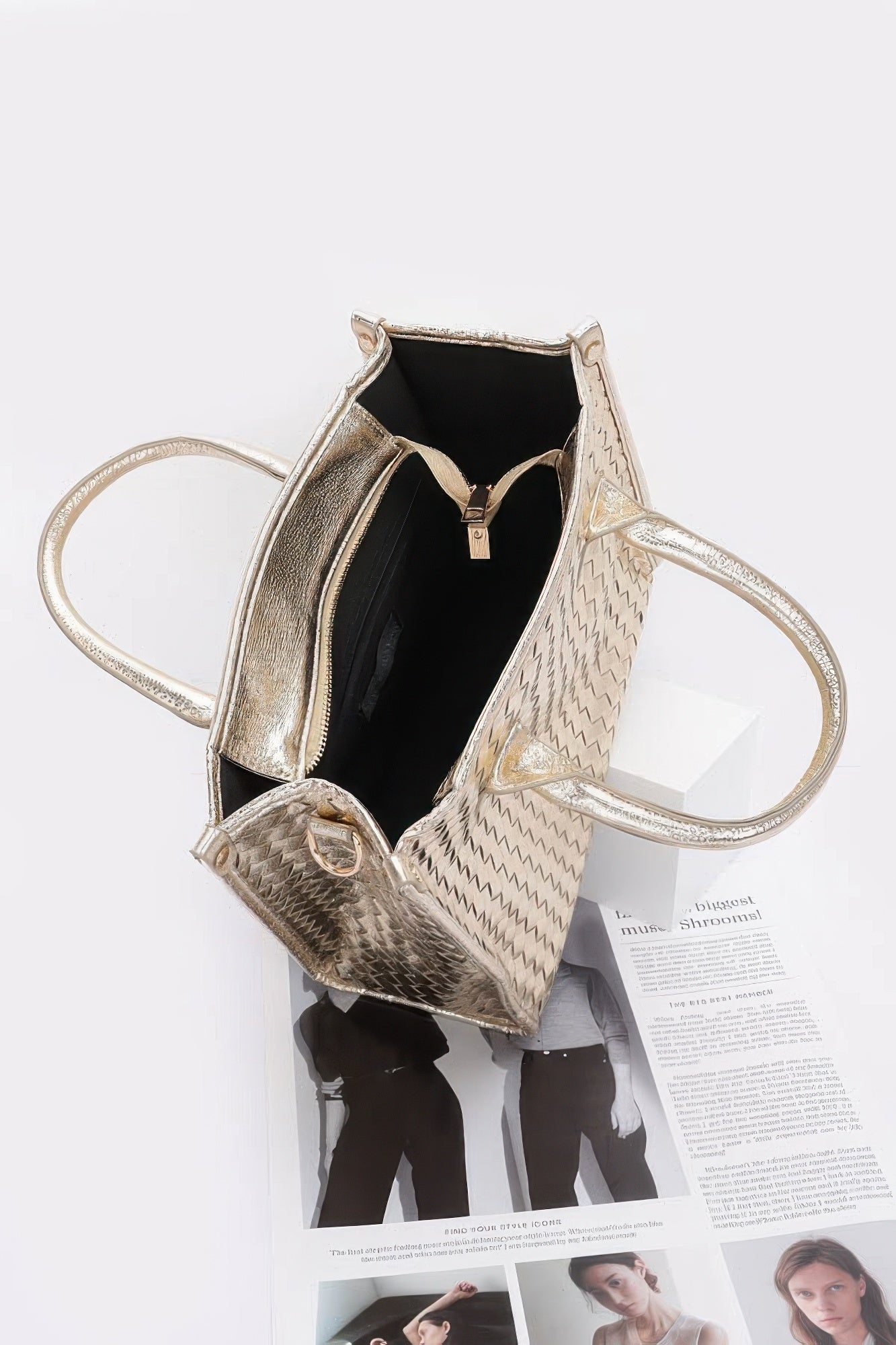 Open metallic braided tote bag showing black interior and zip pocket
