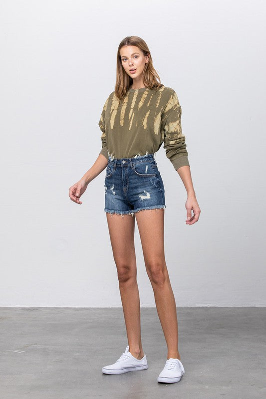 Front view: mid rise distressed dark denim shorts with frayed hem and fading
