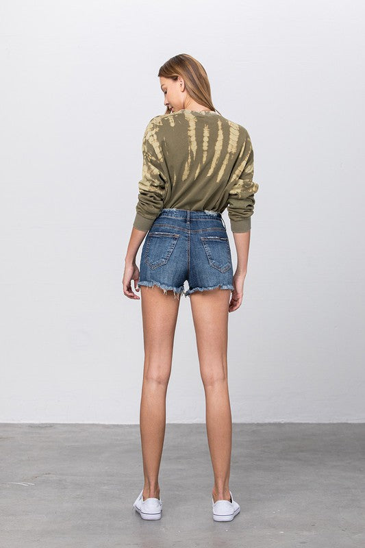 Back view of mid rise distressed dark denim shorts with frayed hem