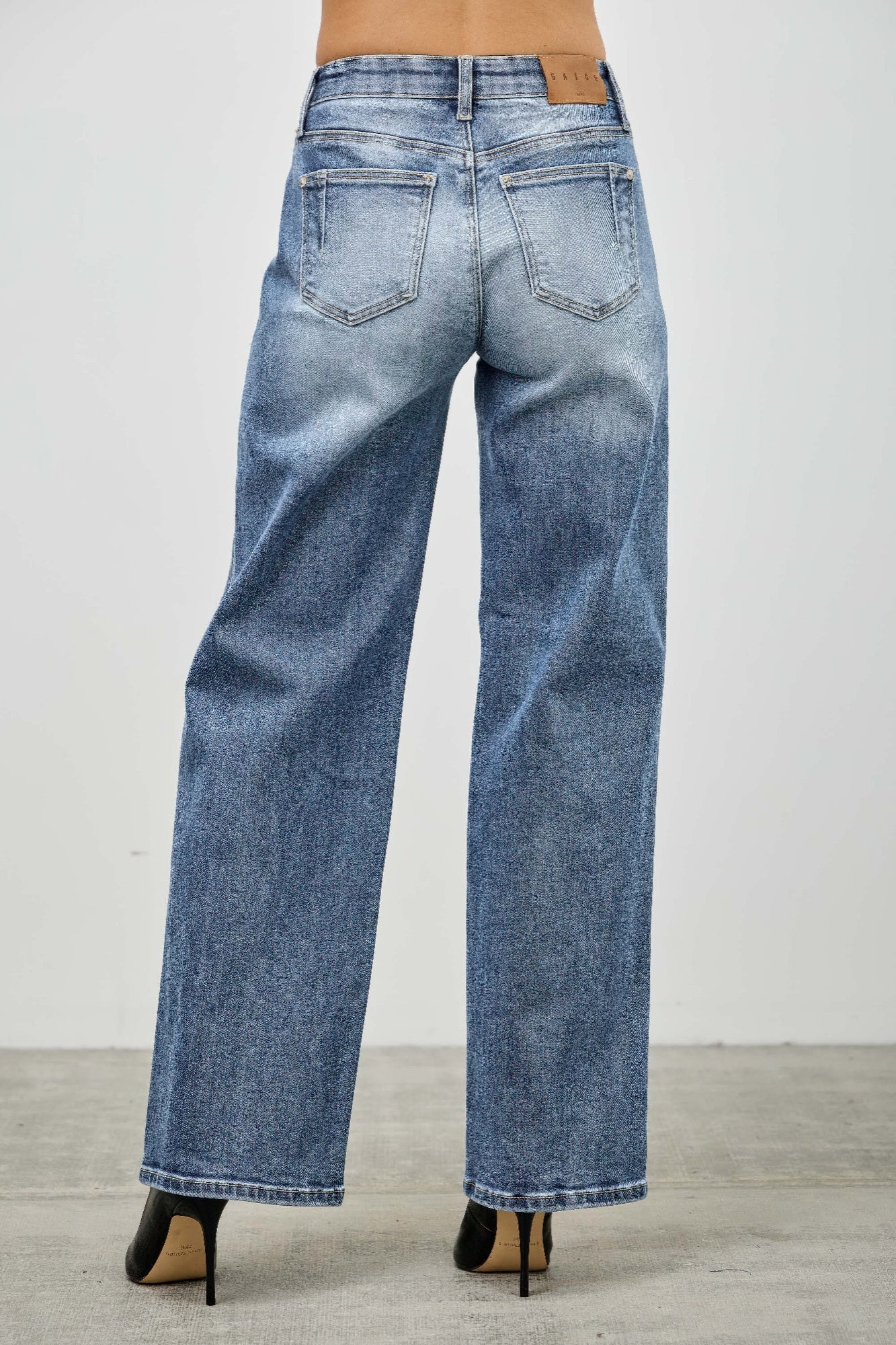 Blue mid-rise straight jeans back view with wide leg opening and stitched pockets
