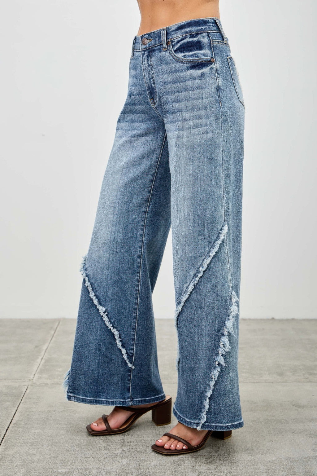Back view: wide-leg jeans with diagonal frayed seam panels and light wash