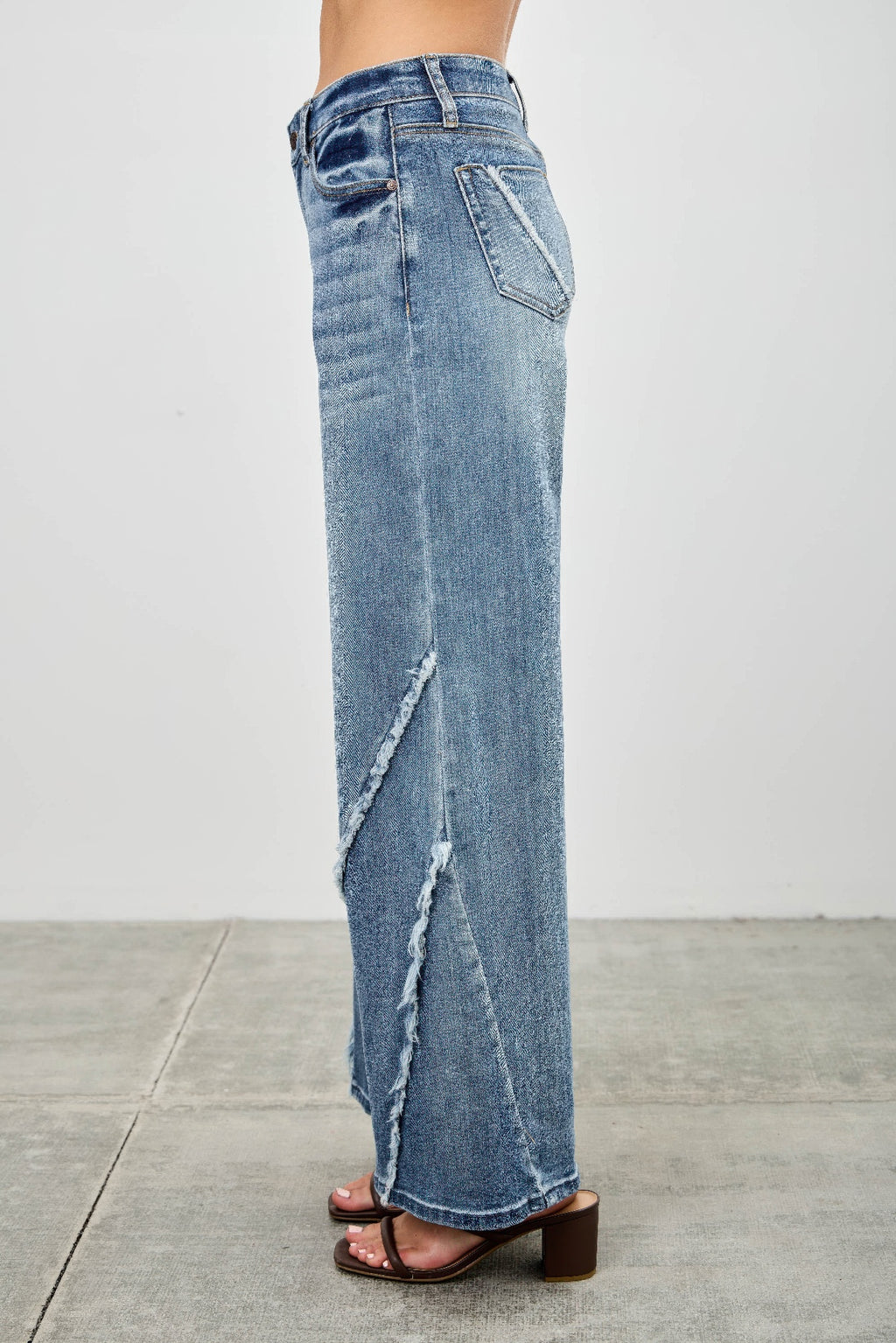 Back/side: light wash wide-leg jeans with diagonal frayed seam and long flare