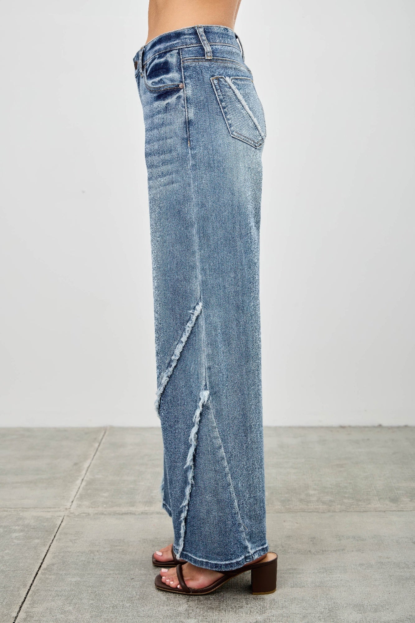 Back/side: light wash wide-leg jeans with diagonal frayed seam and long flare