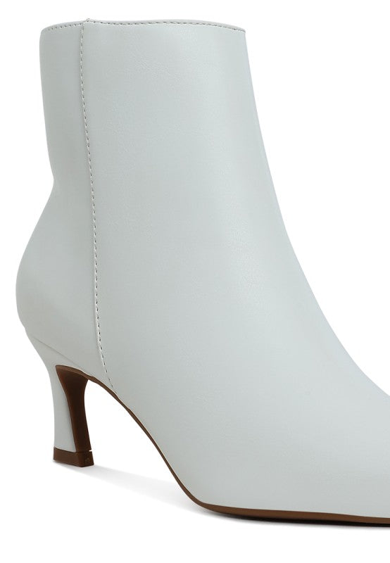 White faux leather ankle boots with stacked block heel and stitched upper