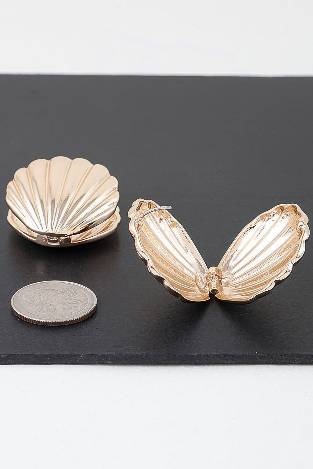 Gold-tone paired clam shell earrings, ridged inner detail, front view