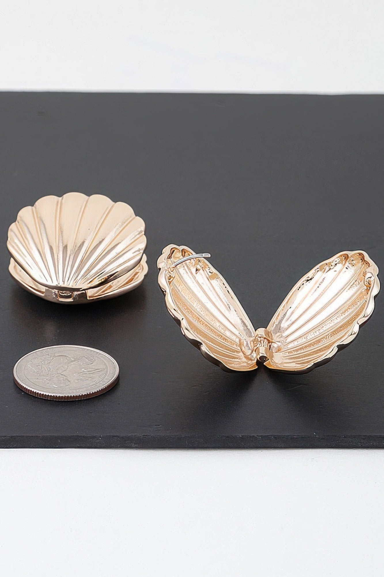 Gold-tone paired clam shell earrings, ridged inner detail, front view