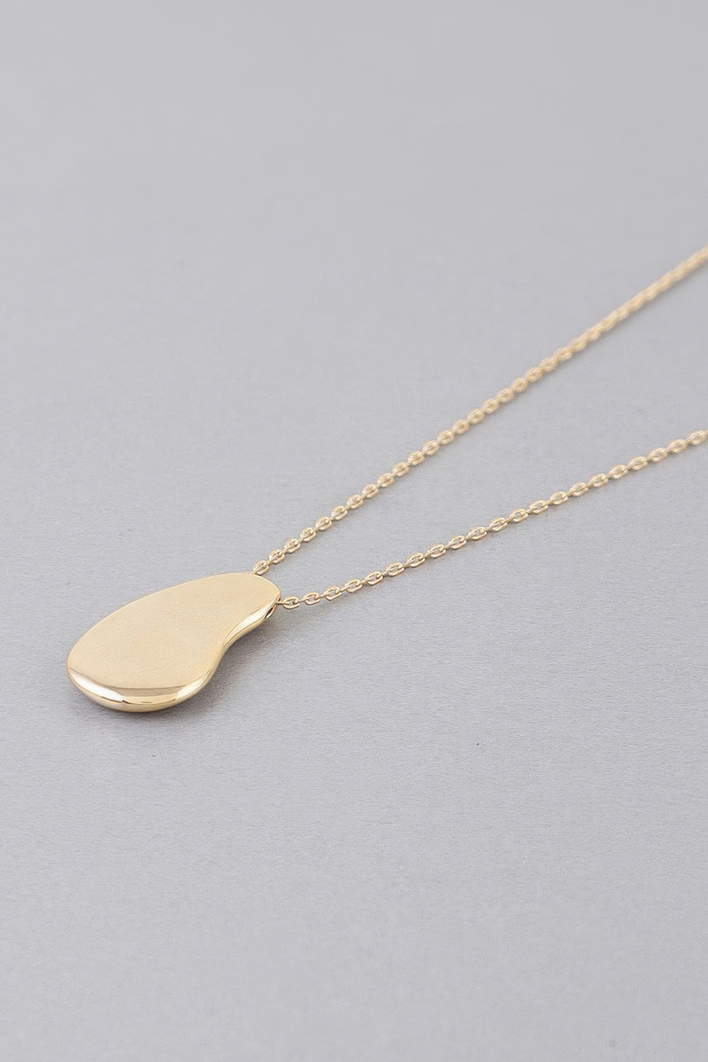 Gold-tone teardrop pendant necklace on thin linked chain