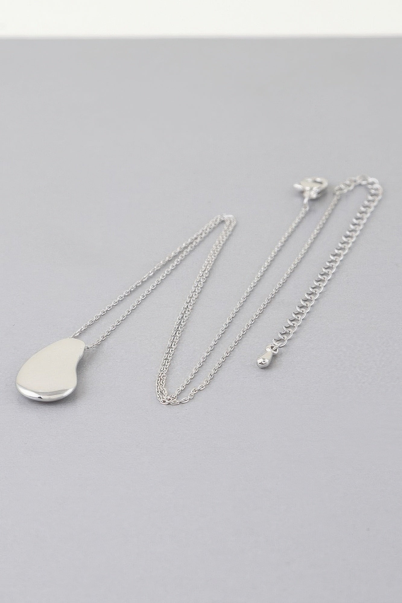Silver-tone teardrop pendant chain necklace with linked chains and clasp