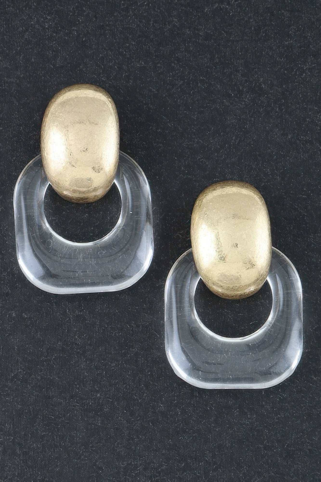 Gold drop earrings with clear curved acrylic hoops and oval gold tops