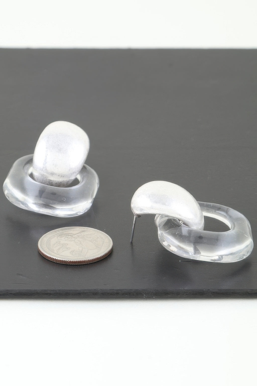 Silver drop earrings with clear curved acrylic hoops and oval silver tops