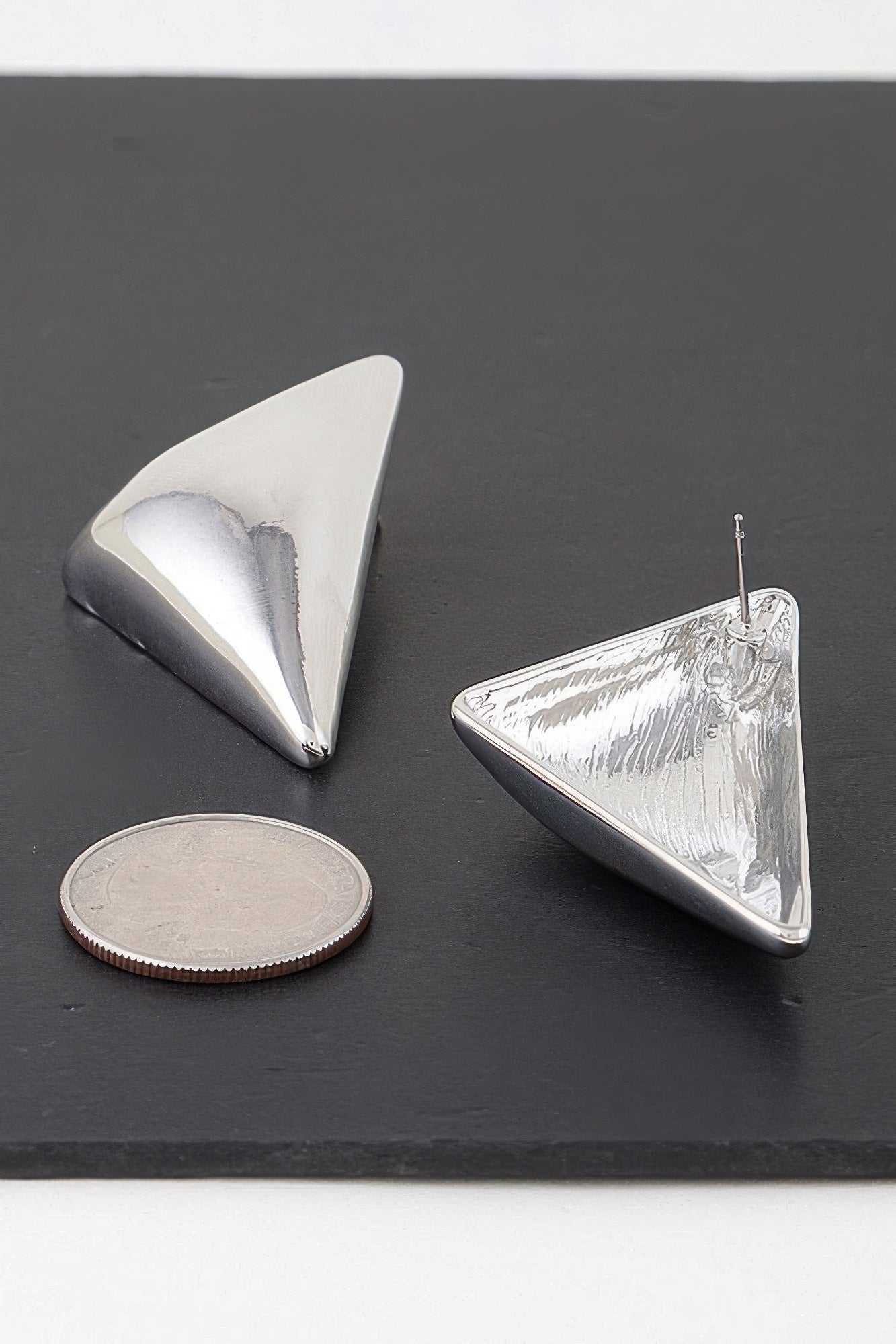 Triangular stud earrings, silver-tone metal, polished faceted front with posts