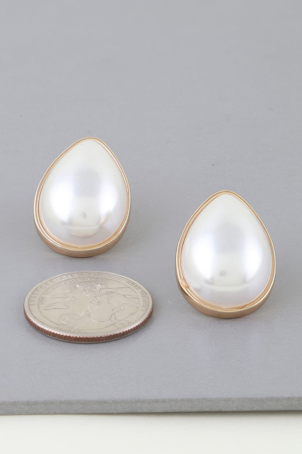 Gold cream teardrop pearl earrings with coin for scale