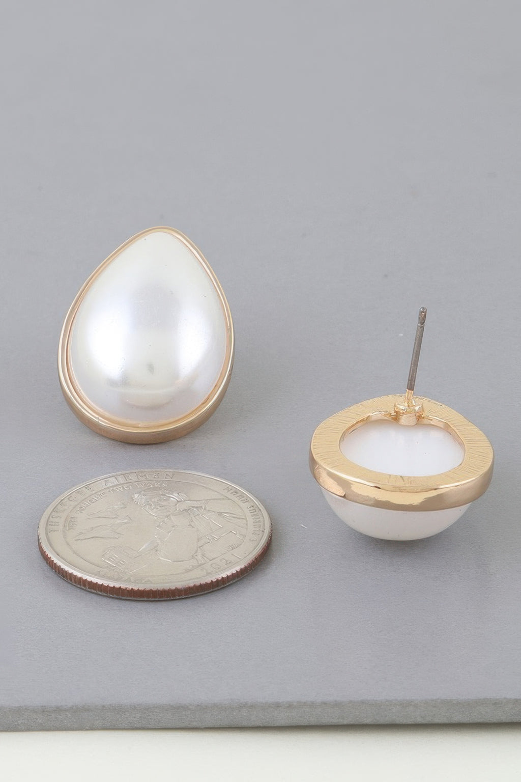 Gold cream teardrop pearl earring with visible back stud and loop