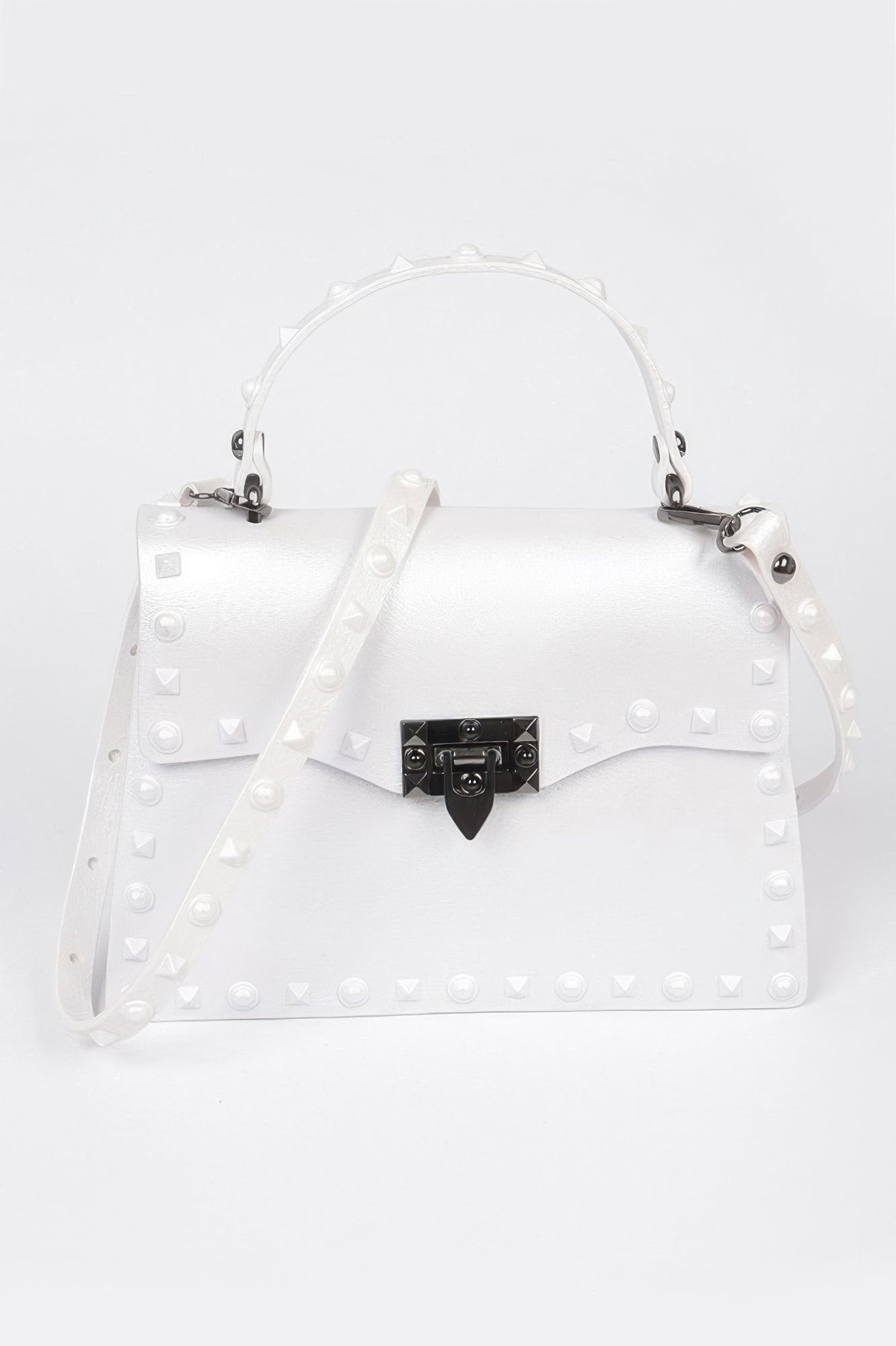 Monotone studded clutch in white with black gem-lock clasp and hanging shoulder strap