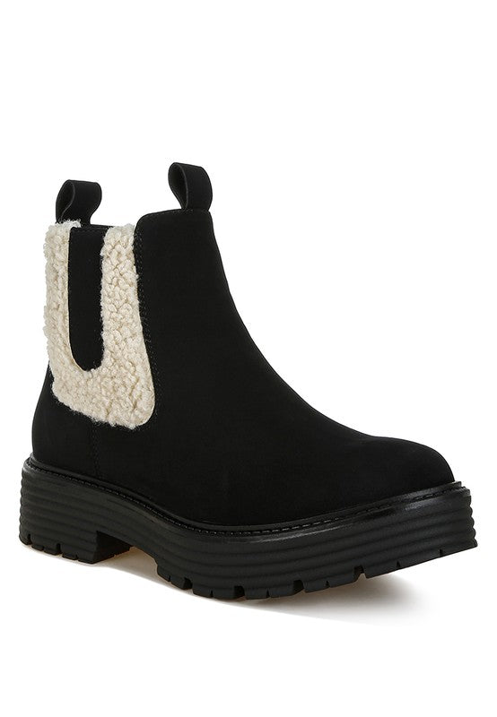 Black ankle boot with sherpa side panel, pull-on heel loop, chunky tread sole