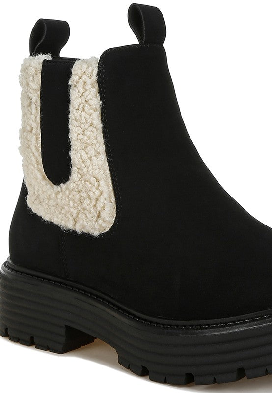 Black ankle boot close-up with sherpa side panel and stacked chunky heel