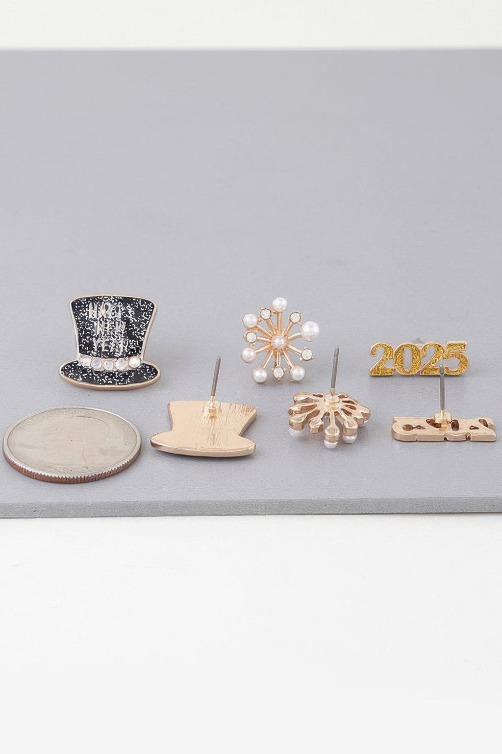 New Year earrings set pieces: black top-hat stud, pearl snowflake, gold 2025 charm
