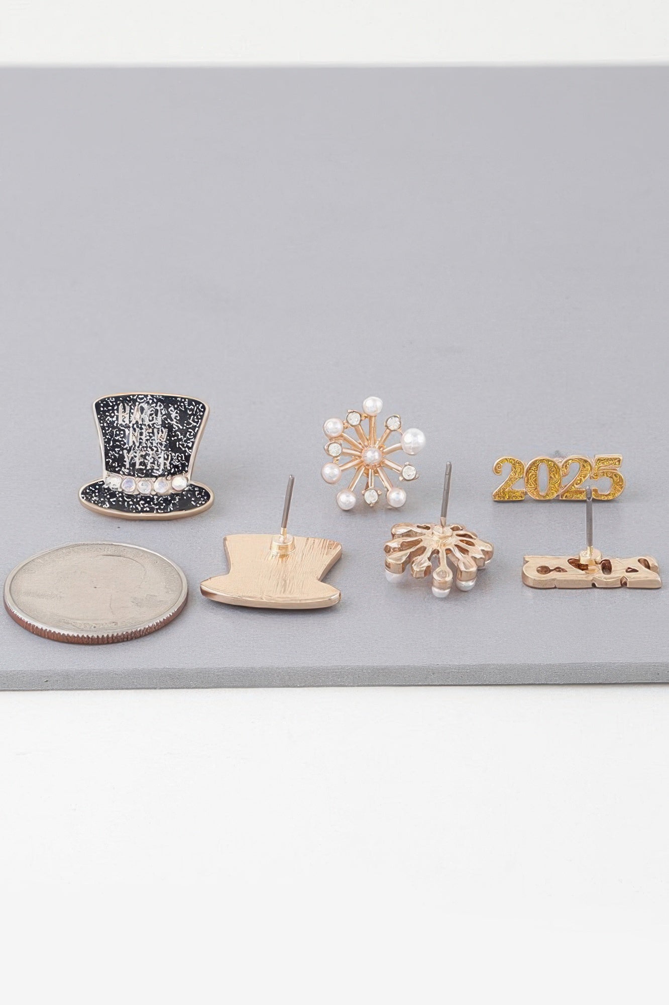New Year earrings set pieces: black top-hat stud, pearl snowflake, gold 2025 charm